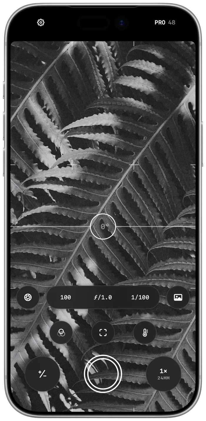 Obscura’s camera view, photographing a stone column in black and white, with exposure, focus and zoom controls within reach of the thumb